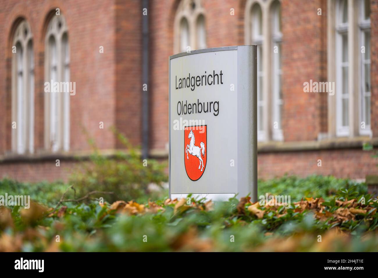 Oldenburg, Deutschland. November 2021. Vor dem Landgericht Oldenburg steht ein Schild. Ein Mann soll hier am Mittwoch vor Gericht stehen, weil er angeblich gefälschte Goldbarren und Krügerrand-Münzen über eine Online-Plattform verkauft hat. Dabei soll er Schäden von rund 40,000 Euro verursacht haben. Kredit: Mohssen Assanimoghaddam/dpa/Alamy Live Nachrichten Stockfoto