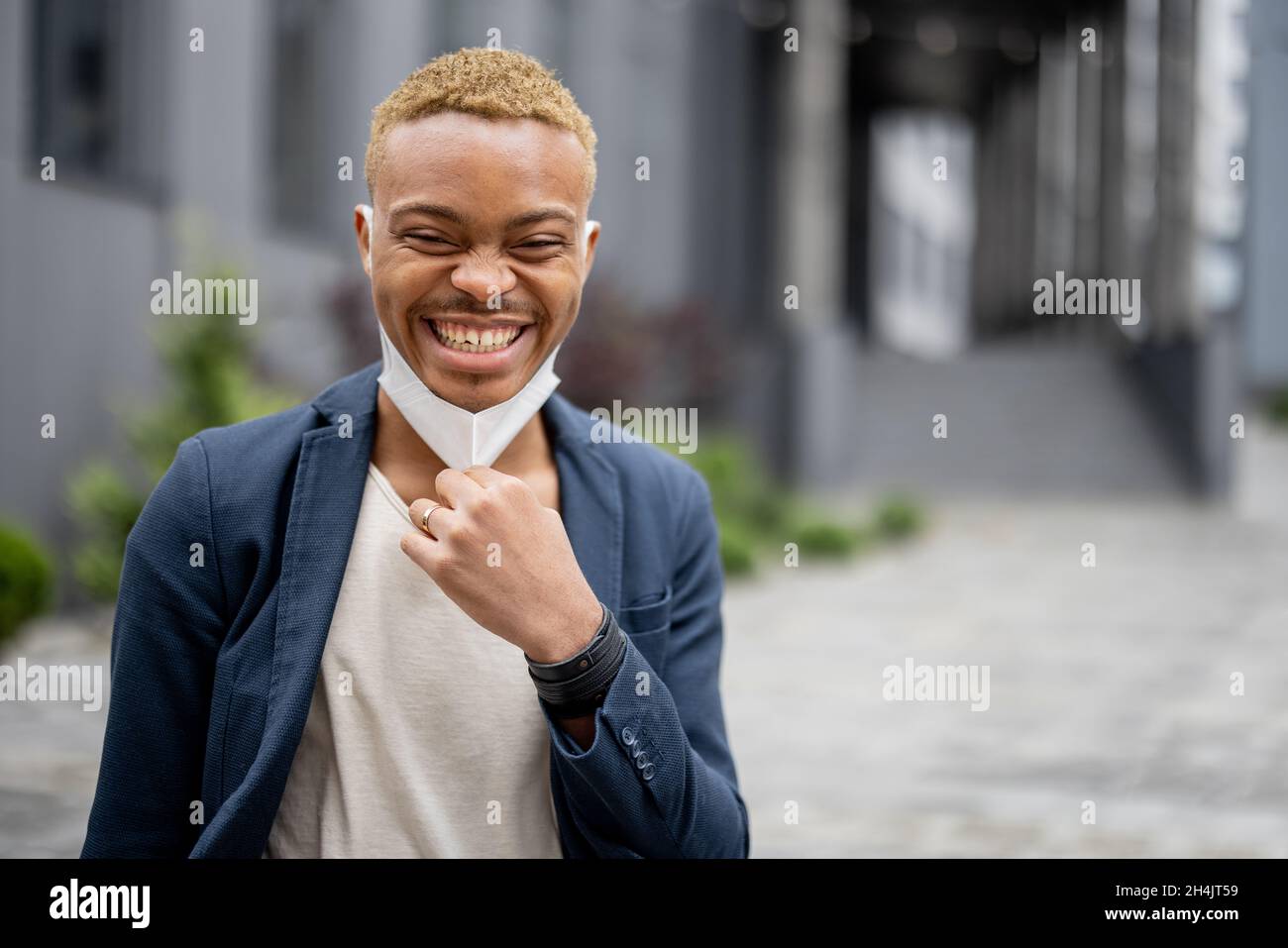 Mann, der die medizinische Maske auszieht und die frische Luft genießt Stockfoto