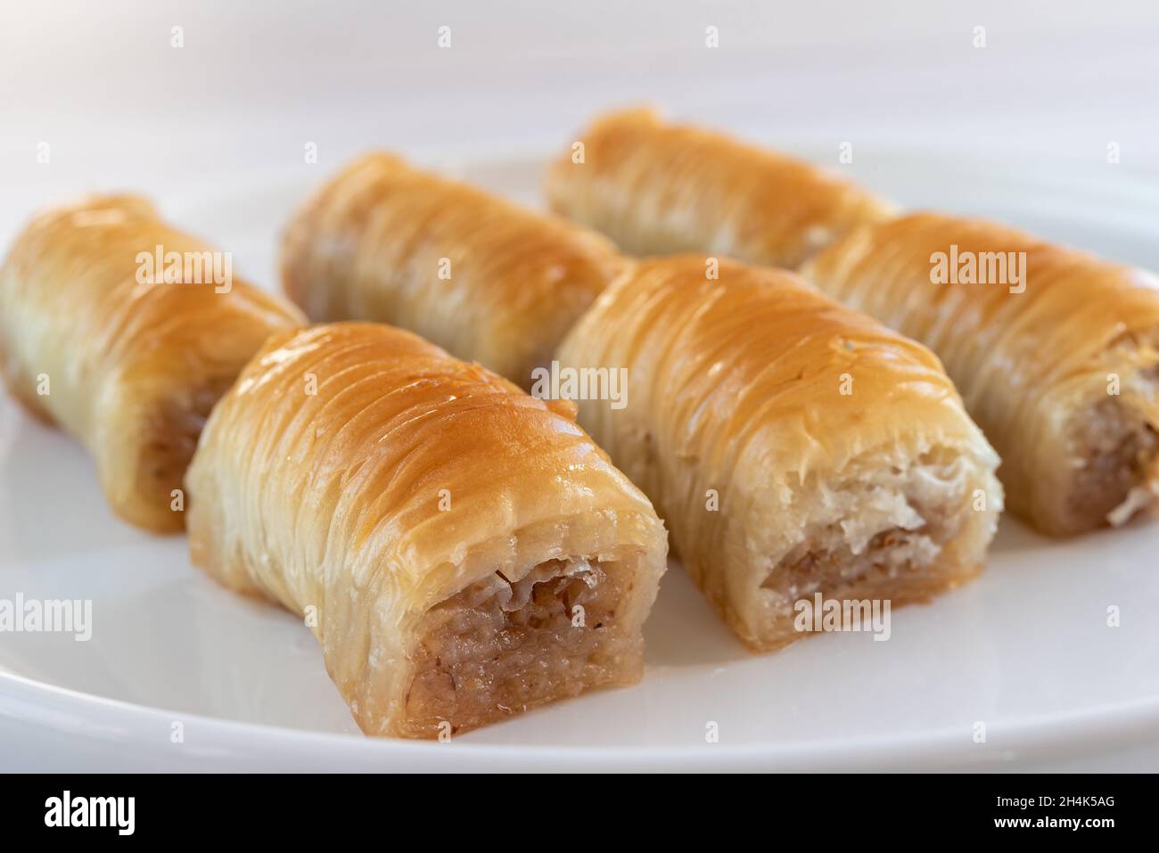 Türkische Süße - Baklava auf einem weißen Teller aus der Nähe. Selektiver Fokus. Stockfoto