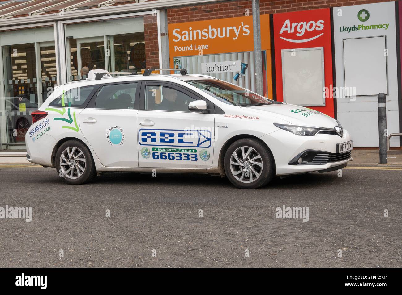 Das örtliche Taxi hielt vor dem Sainsburys Supermarkt und ließ seine Passagiere raus Stockfoto