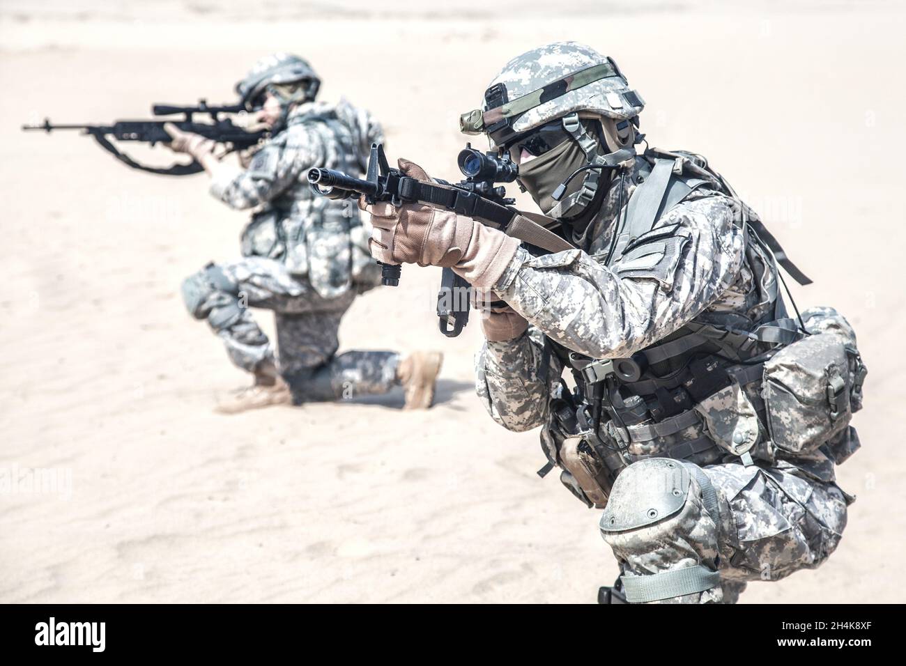 Team von US-amerikanischen flugzeuggestützten Infanteriemännern in Aktion in der Wüste, beschnittene Ansicht. Stockfoto