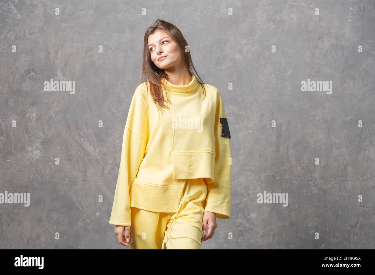 Junge Frau in gelber Sportbekleidung, Hose und Sweatshirt. Konzept der modischen Sport-Outfit, drinnen Foto. Speicherplatz kopieren. Stockfoto