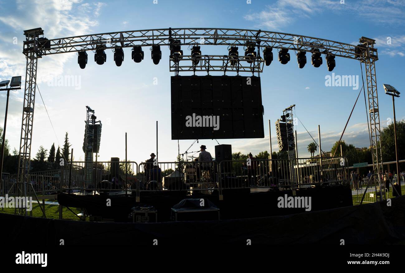 Rock-Tageslicht-Performance von der hinteren Bühne aus gesehen. Sonnenuntergang blauer Himmel Hintergrund. Stockfoto