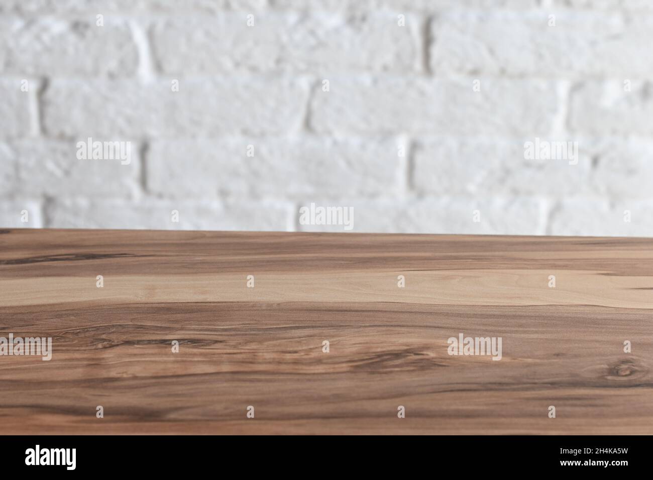 Leere Holztischplatte über weißem Backstein Wand Hintergrund Stockfoto