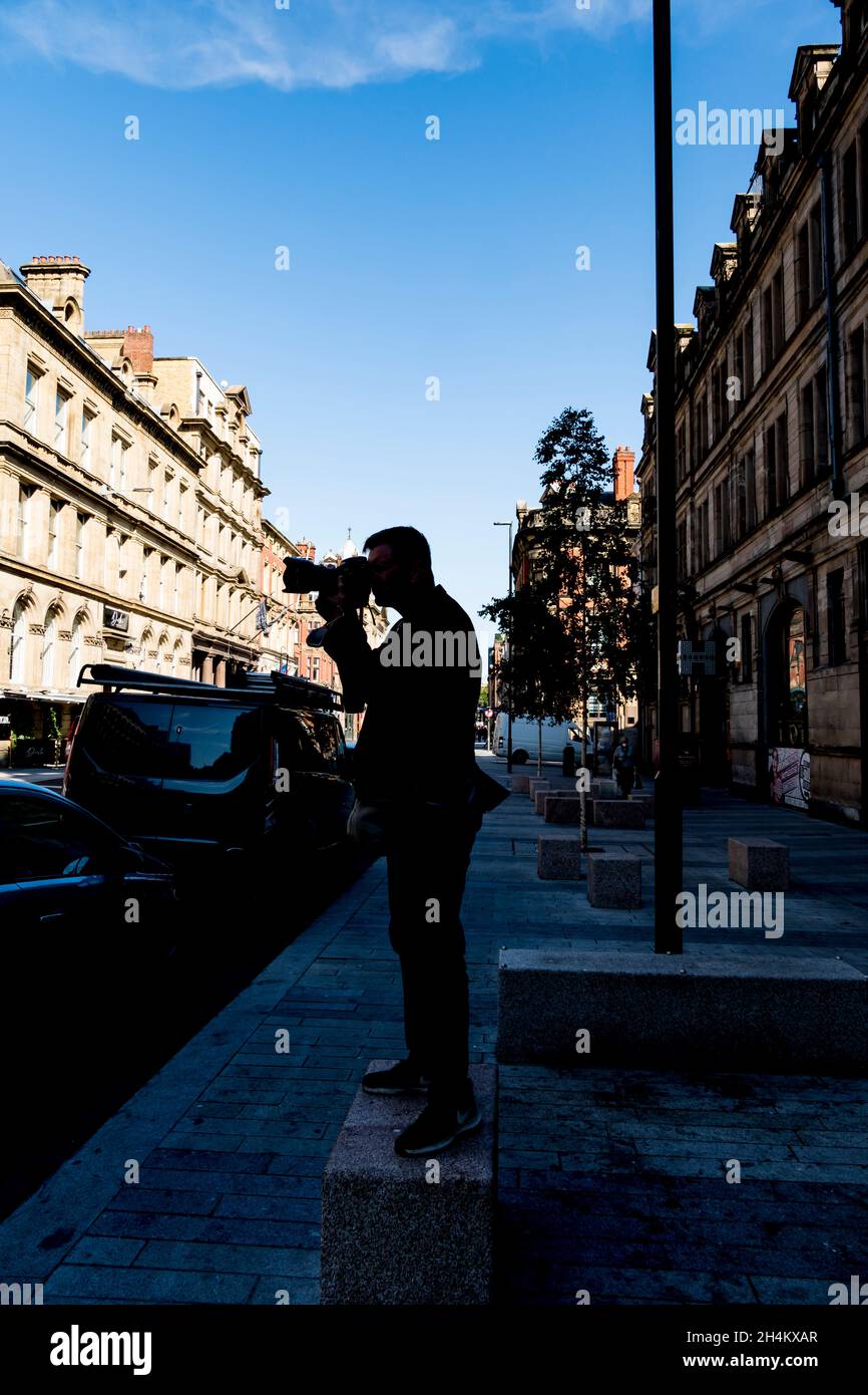 Fotograf steht auf einem Steinblock und fotografiert Victoria Street liverpool 2021 Stockfoto