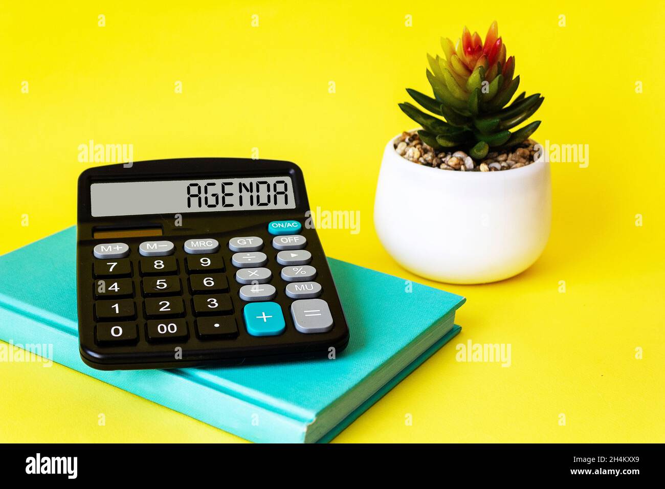 Tagesordnungspunkt auf Rechner und gelber Hintergrund mit Tagebuch und Wecker. Geschäfts- und Finanzkonzept. Stockfoto