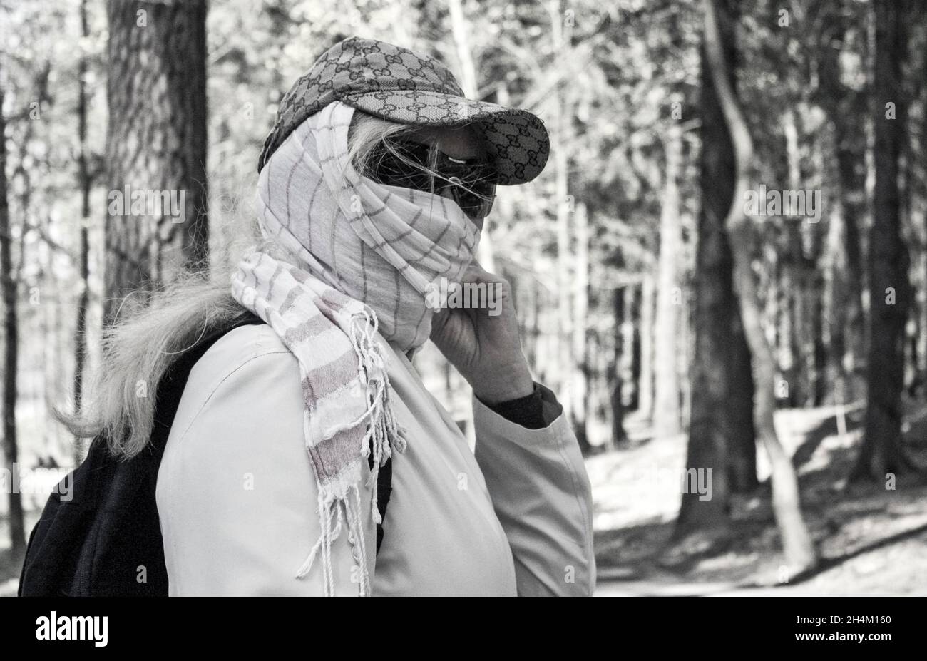 Frau in Maske auf der Straße wegen Luftverschmutzung und Epidemie in der Stadt. Schutz vor Viren, Infektionen, Abgasen und industriellen Emissionen Stockfoto