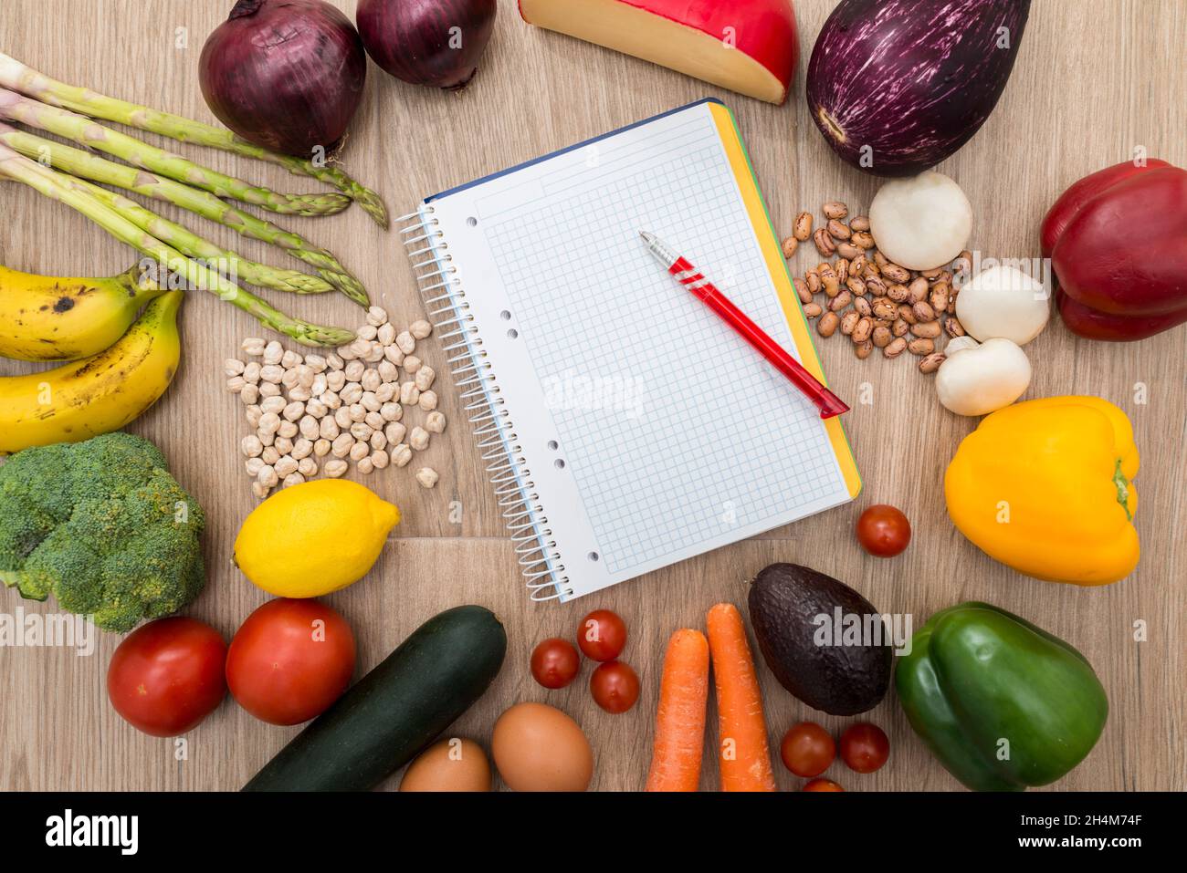Gesundes Essen um ein Notizbuch mit Holzhintergrund. Konzeptuelles Bild von gesunden Diäten. Platz zum Kopieren. Stockfoto