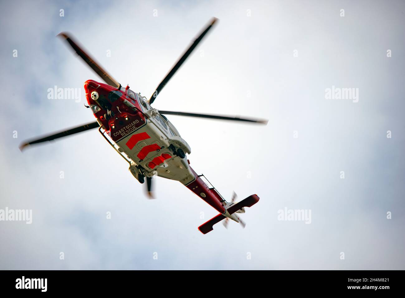 Rot und weiß Coastguard Rettungshubschrauber im Flug Stockfoto