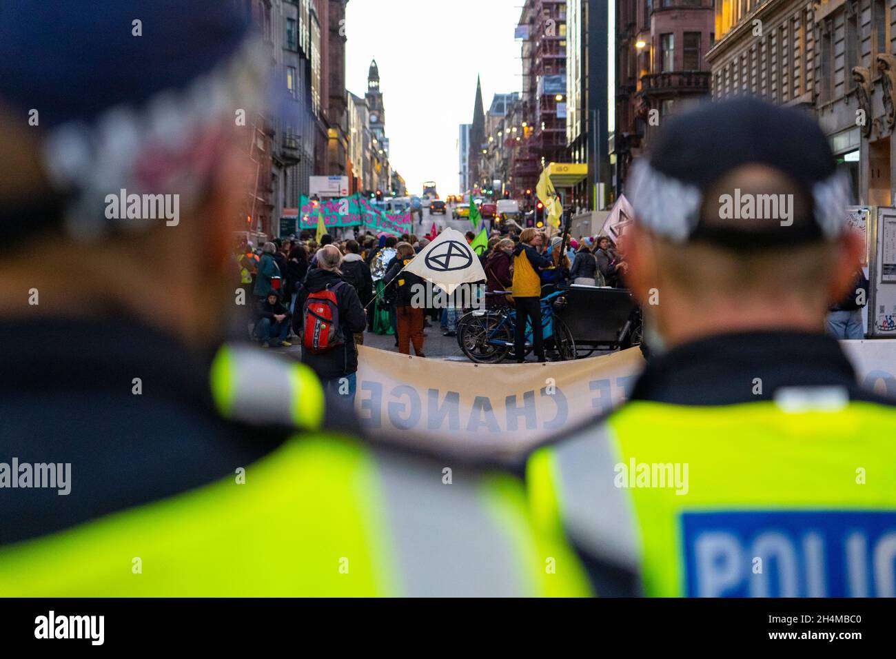 Glasgow, Schottland, Großbritannien. November 2021. Am 4. Tag der UN-Klimakonferenz in Glasgow gab es Demonstrationen der Extinction Rebellion-Protestgruppe im Stadtzentrum von Glasgow. Nachdem sie von der Polizei gejagt wurden, veranstalteten sie eine Sitzveranstaltung, um gegen die Blockierung der St. Vincent Street zu protestieren. Demonstranten wurden später kettiert und durch die Stadt eskortiert und durften am Veranstaltungsort COP26 in Finnieston vorbeilaufen. Iain Masterton/Alamy Live News. Stockfoto