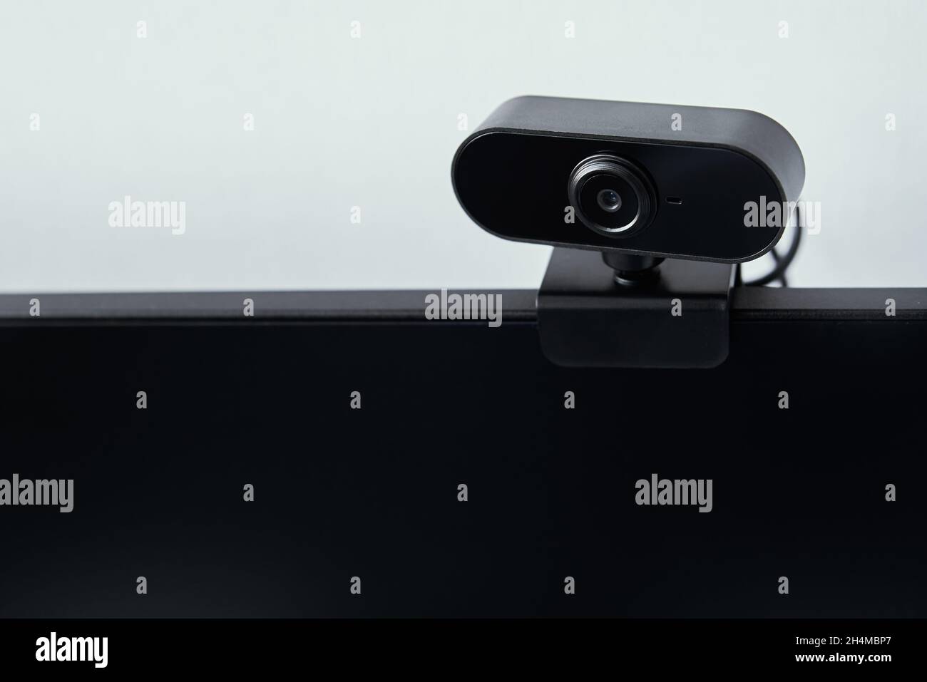 Webcam über dem Computerbildschirm. Schwarze Webcam über schwarzem Bildschirm. Digitales Sicherheitskonzept Stockfoto