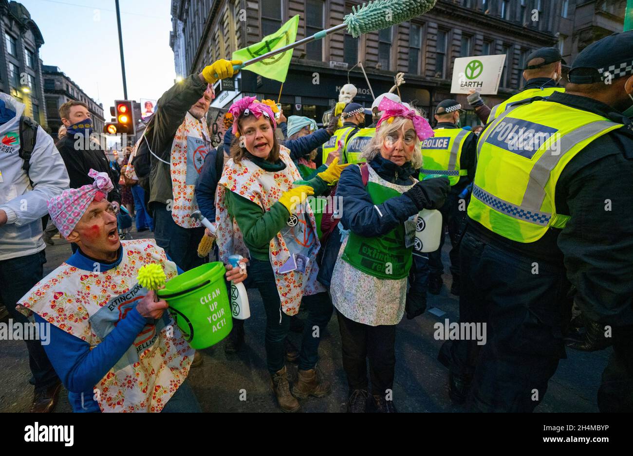 Glasgow, Schottland, Großbritannien. November 2021. Am 4. Tag der UN-Klimakonferenz in Glasgow gab es Demonstrationen der Extinction Rebellion-Protestgruppe im Stadtzentrum von Glasgow. Nachdem sie von der Polizei gejagt wurden, veranstalteten sie eine Sitzveranstaltung, um gegen die Blockierung der St. Vincent Street zu protestieren. Demonstranten wurden später kettiert und durch die Stadt eskortiert und durften am Veranstaltungsort COP26 in Finnieston vorbeilaufen. PIC; die schmutzigen Schrubber versuchen, die Polizei zu säubern, Teil ihres Greenwash-Protests. Iain Masterton/Alamy Live News. Stockfoto