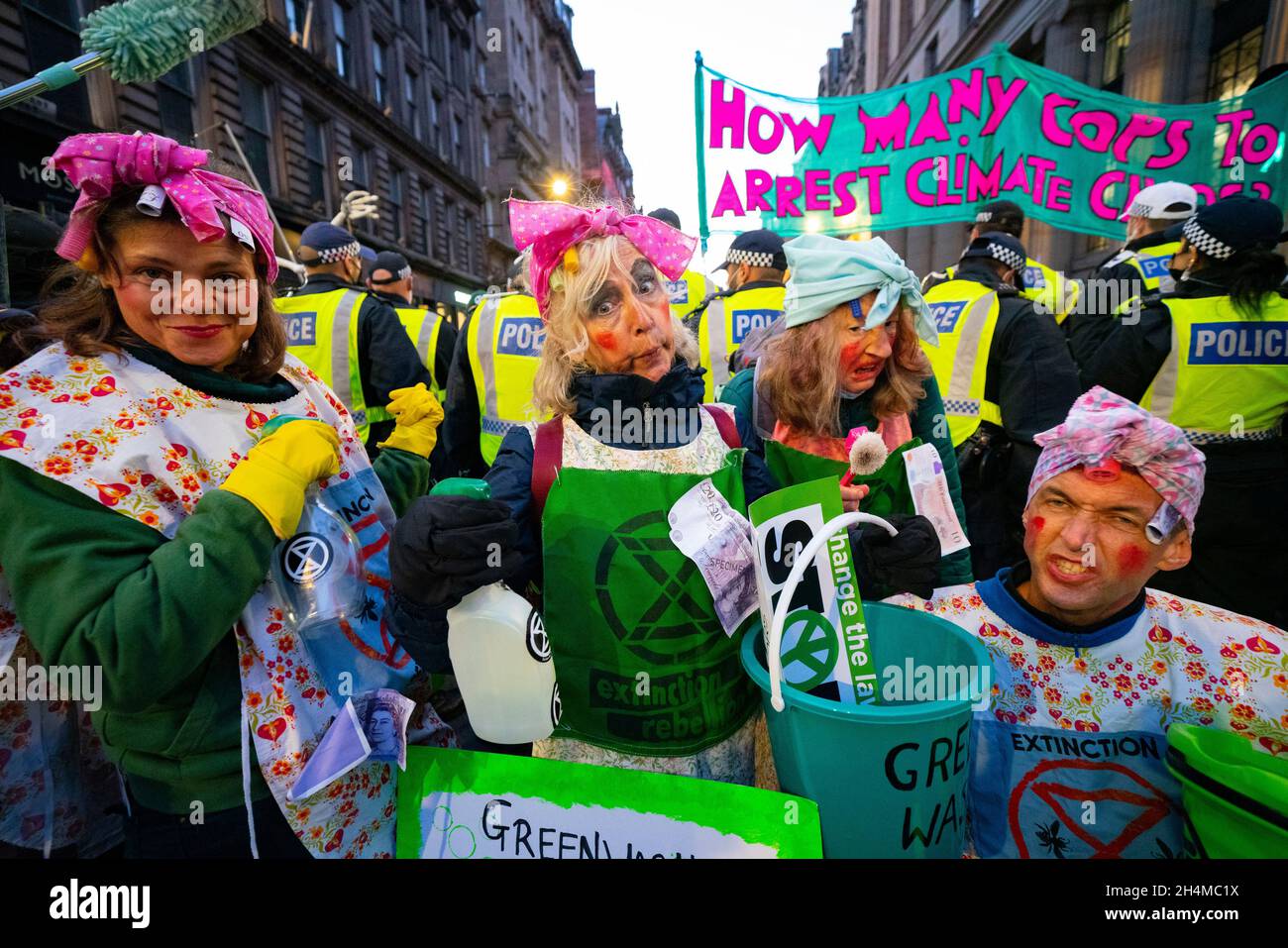 Glasgow, Schottland, Großbritannien. November 2021. Am 4. Tag der UN-Klimakonferenz in Glasgow gab es Demonstrationen der Extinction Rebellion-Protestgruppe im Stadtzentrum von Glasgow. Nachdem sie von der Polizei gejagt wurden, veranstalteten sie eine Sitzveranstaltung, um gegen die Blockierung der St. Vincent Street zu protestieren. Demonstranten wurden später kettiert und durch die Stadt eskortiert und durften am Veranstaltungsort COP26 in Finnieston vorbeilaufen. PIC; die schmutzigen Schrubber versuchen, die Polizei zu säubern, Teil ihres Greenwash-Protests. Iain Masterton/Alamy Live News. Stockfoto