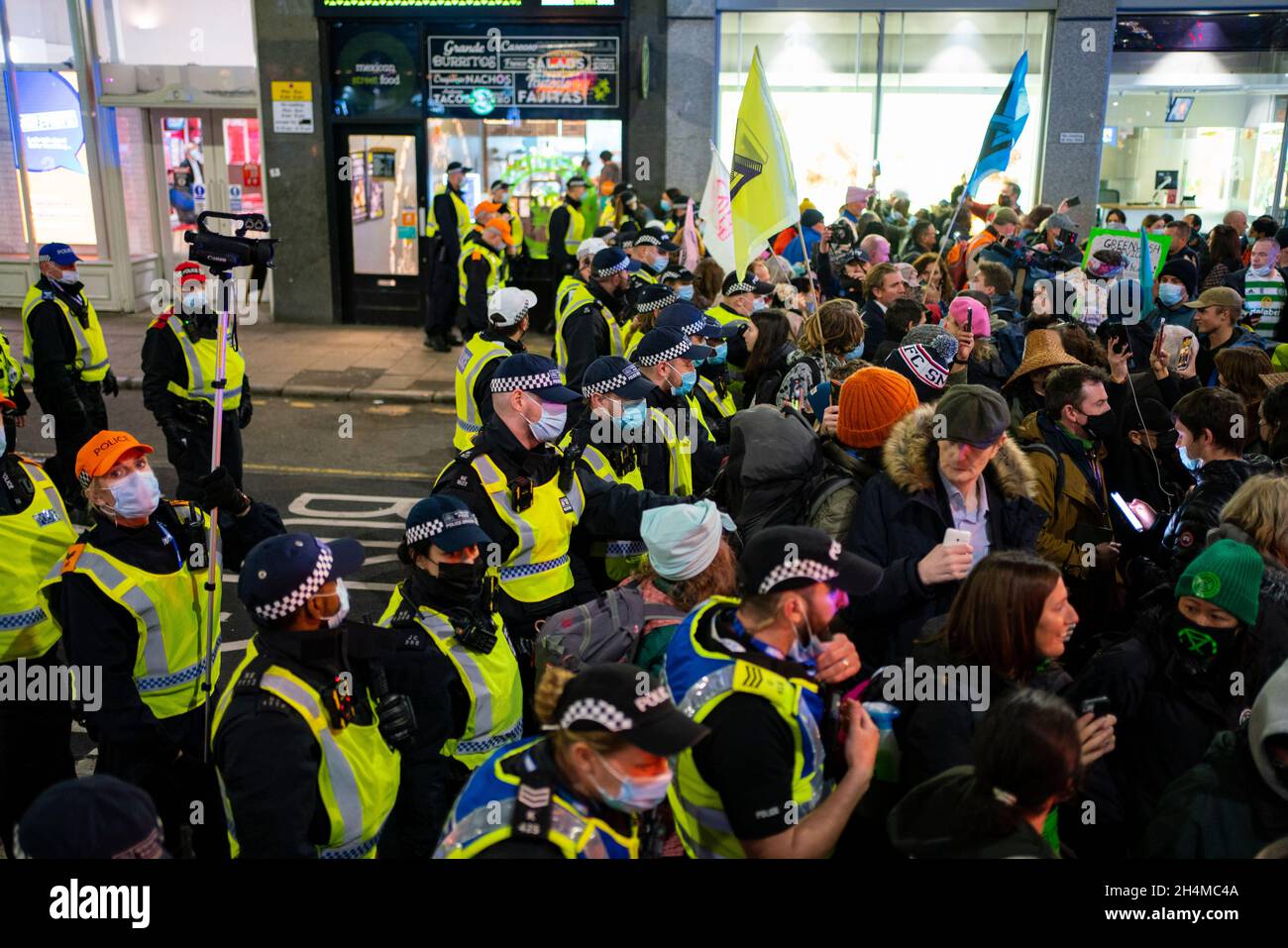 Glasgow, Schottland, Großbritannien. November 2021. Am 4. Tag der UN-Klimakonferenz in Glasgow gab es Demonstrationen der Extinction Rebellion-Protestgruppe im Stadtzentrum von Glasgow. Nachdem sie von der Polizei gejagt wurden, veranstalteten sie eine Sitzveranstaltung, um gegen die Blockierung der St. Vincent Street zu protestieren. Demonstranten wurden später kettiert und durch die Stadt eskortiert und durften am Veranstaltungsort COP26 in Finnieston vorbeilaufen. Iain Masterton/Alamy Live News. Stockfoto
