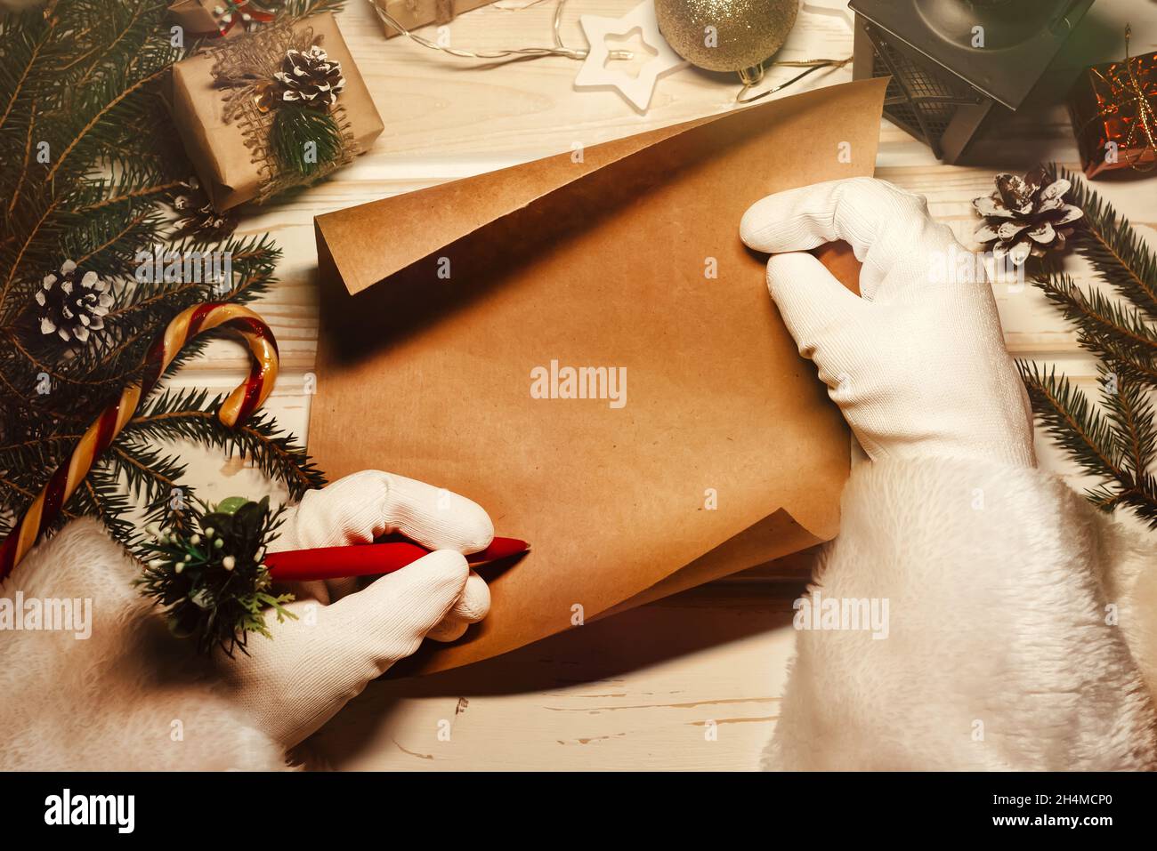 Die Hände des weihnachtsmannes schreiben einen Brief mit Neujahrs-Grüßen. Festliche Weihnachten Hintergrund. Stockfoto