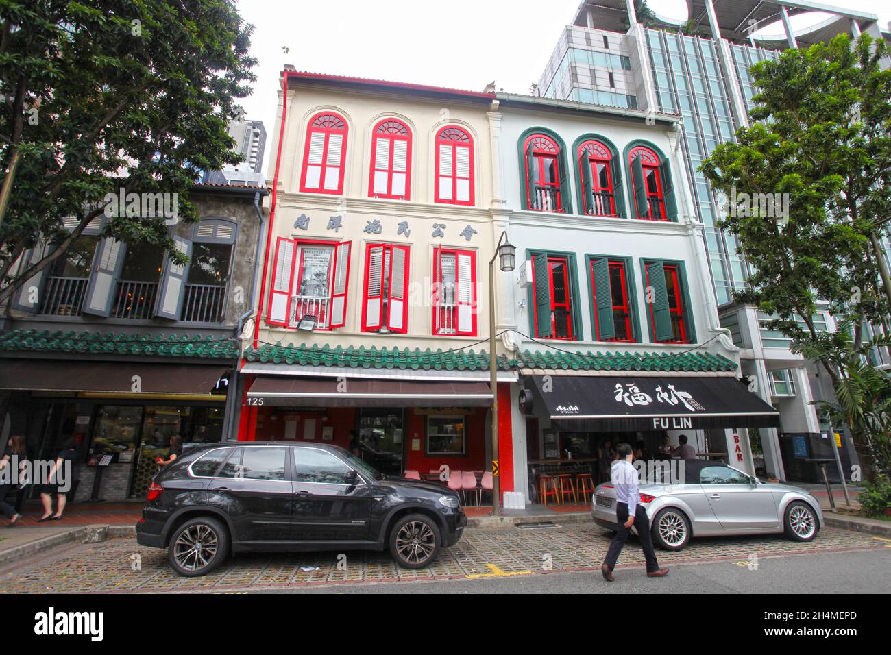 Alte Geschäftshäuser in der Telok Ayer Street in Singapurs Chinatown-Viertel mit Menschen, die auf der Straße spazieren. Stockfoto