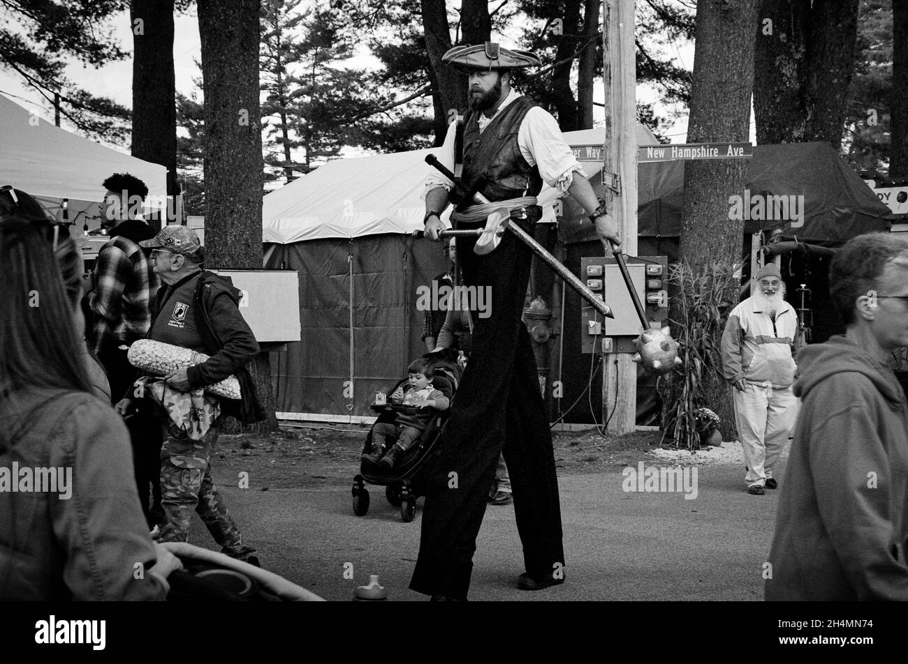 Ein Riese mit mase, Schwert und Axt geht auf der Deerfield Fair - Deerfield, New Hampshire, durch die Menge. Schwarz-Weiß-Ilford XP2-Film. Stockfoto