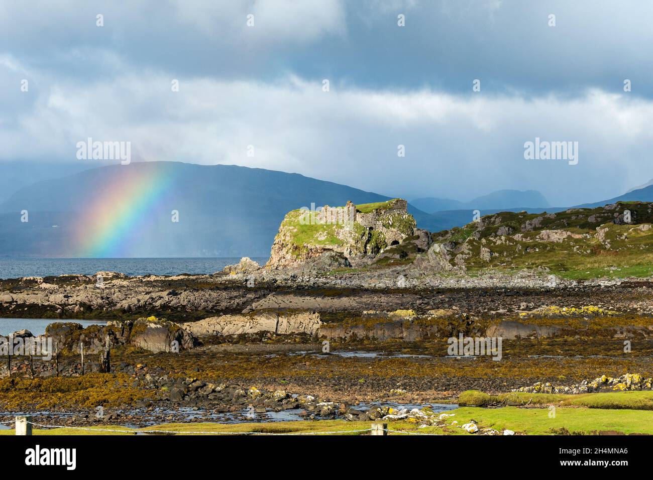Dunscaith (Dun Scaich) Burgruinen und Regenbogen in Tokavaig mit Black Cuillin Mountains Beyond, Isle of Skye, Schottland, Großbritannien. Stockfoto