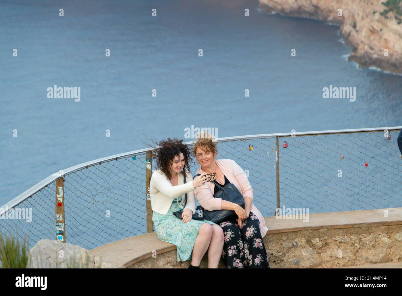 Zwei Frauen machen Selfie vor Klippen mit Meer unter Mirador Es Colomer Mallorca Spanien Stockfoto