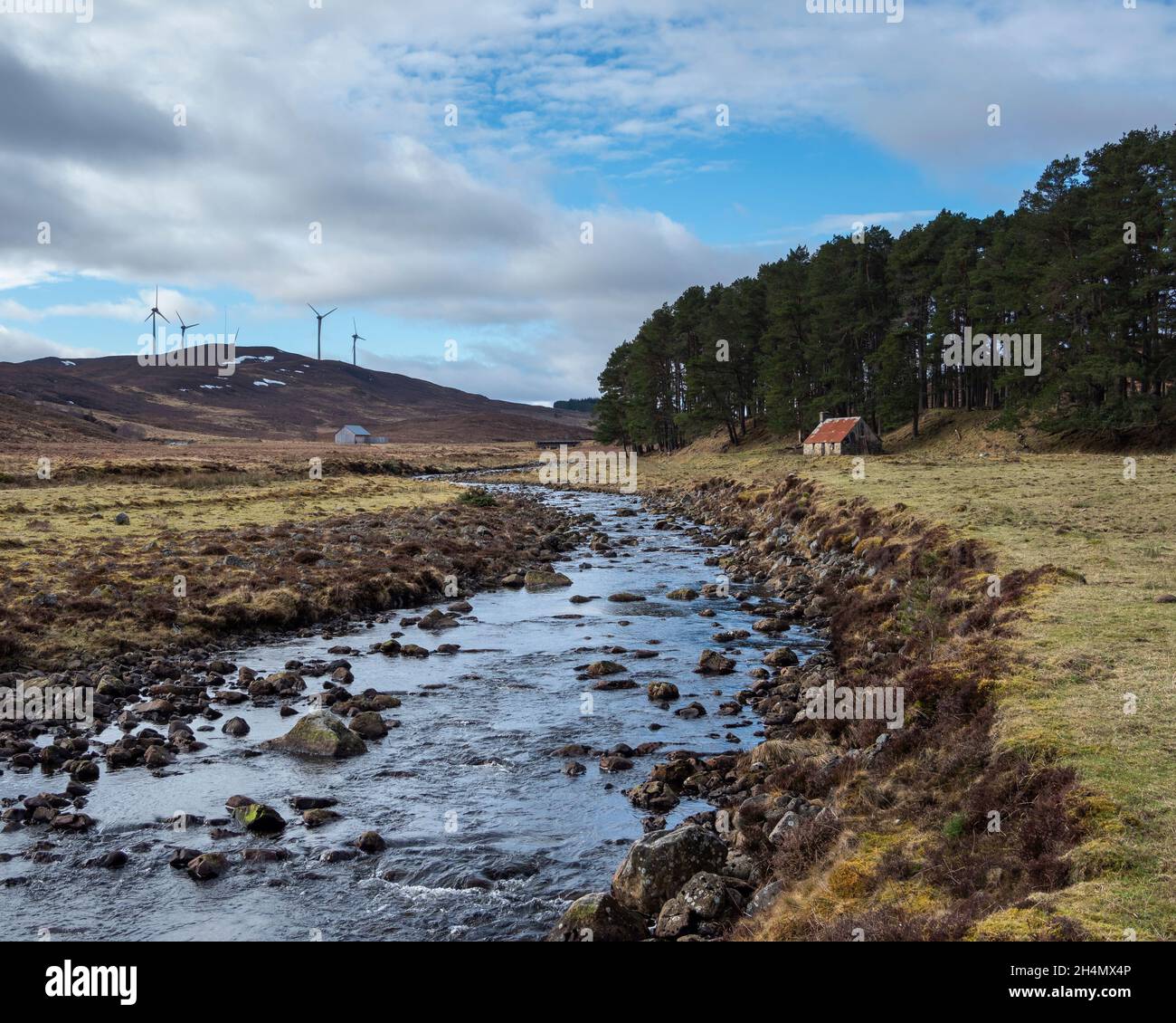 Der Fluss Enrick mit dem Corrimony-Tal auf der rechten Seite und der Windpark Corrimony in der Ferne. Corrimony in der Nähe von Cannich, Highland, Schottland Stockfoto