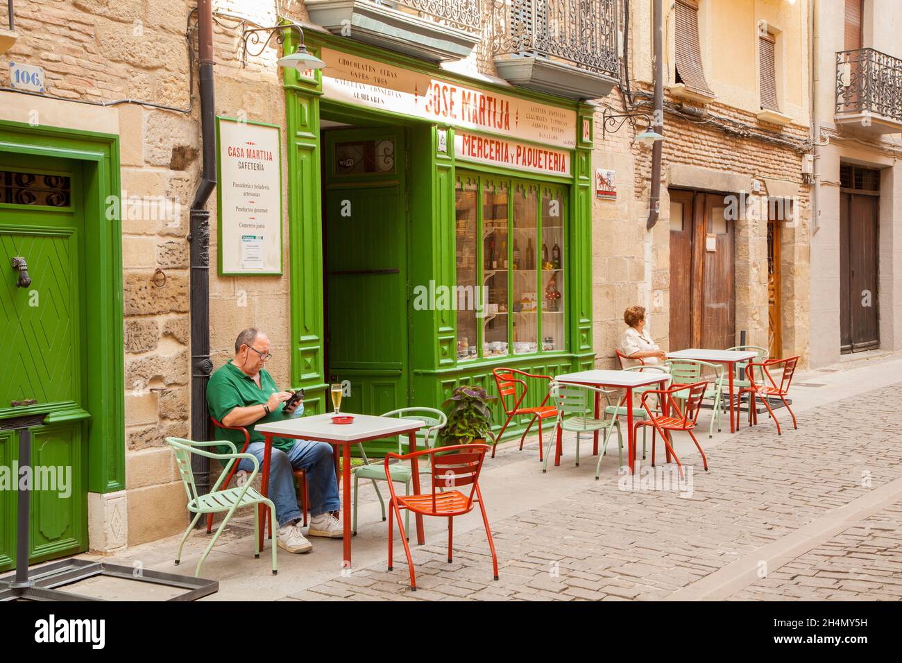 Mann sitzt vor einem Café / Bar mit einem Glas Bier in der spanischen Stadt Puente la Reina Navarra Spanien Teil des Camino de Santiago de Santiago Stockfoto