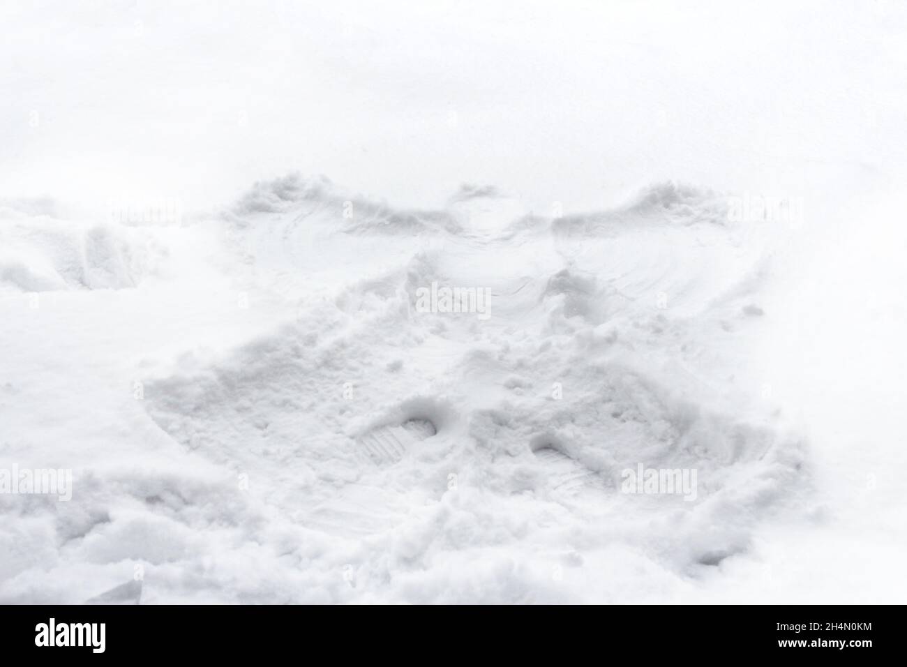 Schneeengel im weißen Schnee gemacht. Seitenansicht. Spuren auf der Schneeoberfläche. Draußen, draußen, kaltes Wetter. Ein lustiger Urlaub. Genießen Sie den Winter. Stockfoto