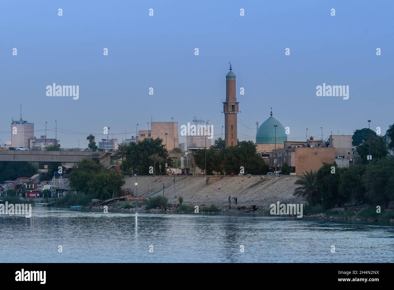 Bagdad, Irak - 11. Oktober 2021: Abendansicht der Al Takarta Moschee mit Blick auf den Tigris Fluss und der Großen Torbrücke im Hintergrund in Ha Stockfoto