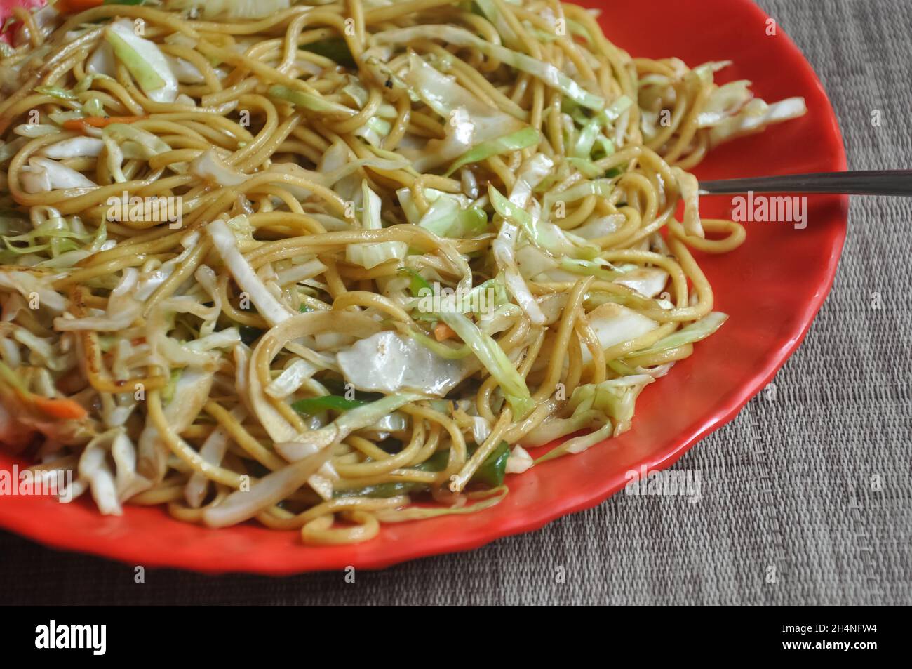 Blick auf Chowmein (Nudeln), serviert in roten Farbteller im Café Stockfoto