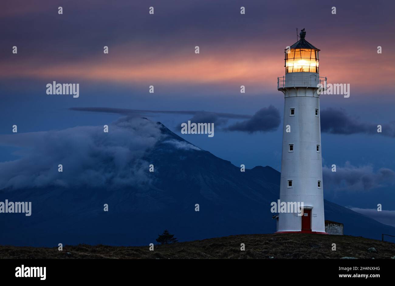 Cape Egmont Leuchtturm und Taranaki Mount im Hintergrund, Neuseeland Stockfoto