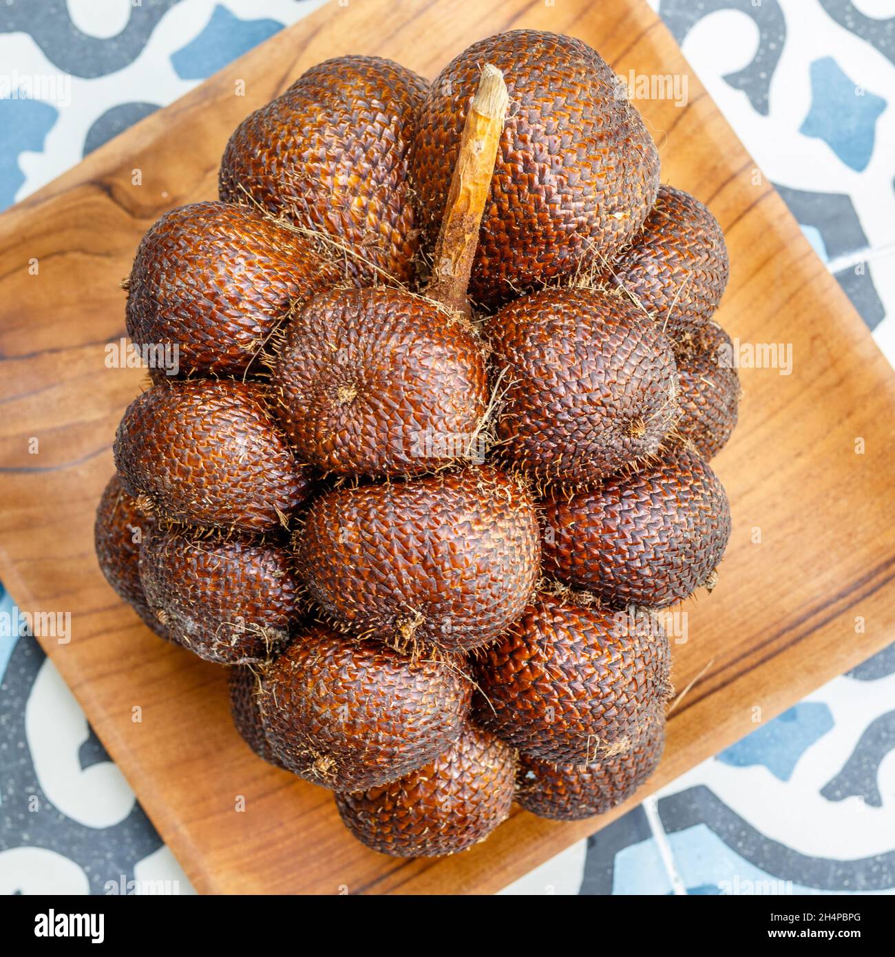 Ein Haufen Salak Bali oder Schlangenfrucht auf einem Holztablett Bali, Indonesien. Quadratisches Bild. Stockfoto