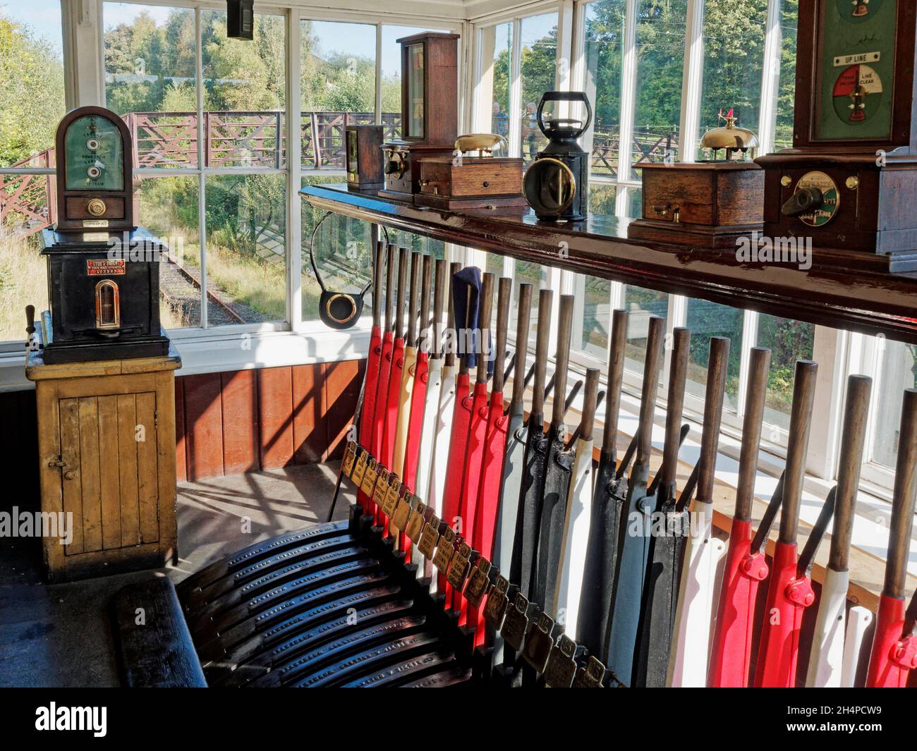 Innenraum der Signalbox an der neu erstellten Rowley Station im Beamish Museum mit lebernem Rahmen und Token-Maschine. Stockfoto