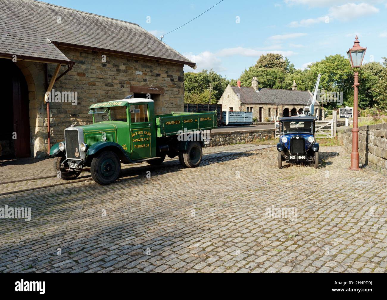 Die Fahrzeuge der 30er Jahre stellen eine Szene aus der Vergangenheit auf dem Güterbahnhof der Rowley Station dar, einer wiederaufgebauten Zweigstelle am Beamish Museum. Stockfoto