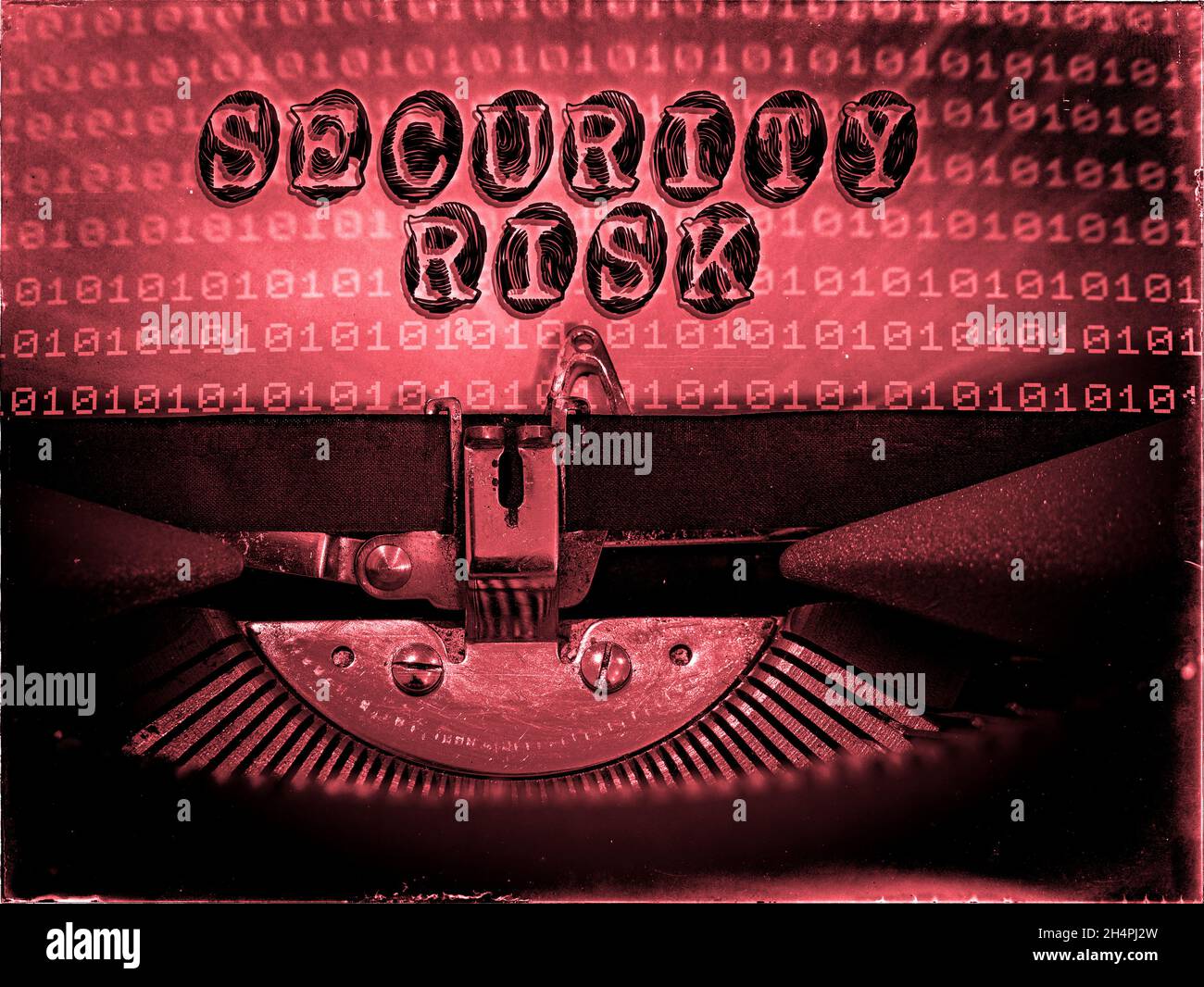Sicherheitsrisiko wird auf einer alten Schreibmaschine mit binärem Code-Hintergrund angezeigt Stockfoto