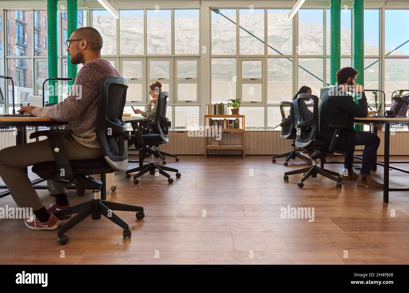 Eine Gruppe verschiedener junger Geschäftsleute, die an ihrem Schreibtisch in einem Büro arbeiten Stockfoto