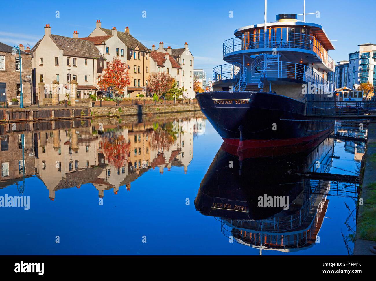 Water of Leith, The Shore, Edinburgh, Schottland, Großbritannien. November 2021. Herbst Sonnenschein Reflexionen an einem kalten, ruhigen Morgen. Temperatur 2 Grad Celsius. Im Bild: Der Ocean Mist im Vordergrund wird noch renoviert, soll aber laut aktuellen Berichten der Besitzer bald geöffnet werden. Luxuriöses, schwimmendes Boutique-Hotel mit 17 Schlafzimmern und Bar, fest in Leith an der Edinburgh Waterfront gelegen. Eröffnung im Frühjahr 2021. Quelle: Arch White/Alamy Live News. Stockfoto