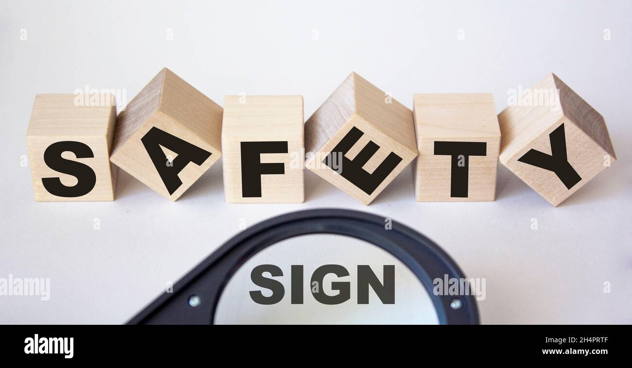 Auf Holzwürfeln Text Sicherheit und Lupe mit Textzeichen auf weißem Hintergrund Stockfoto