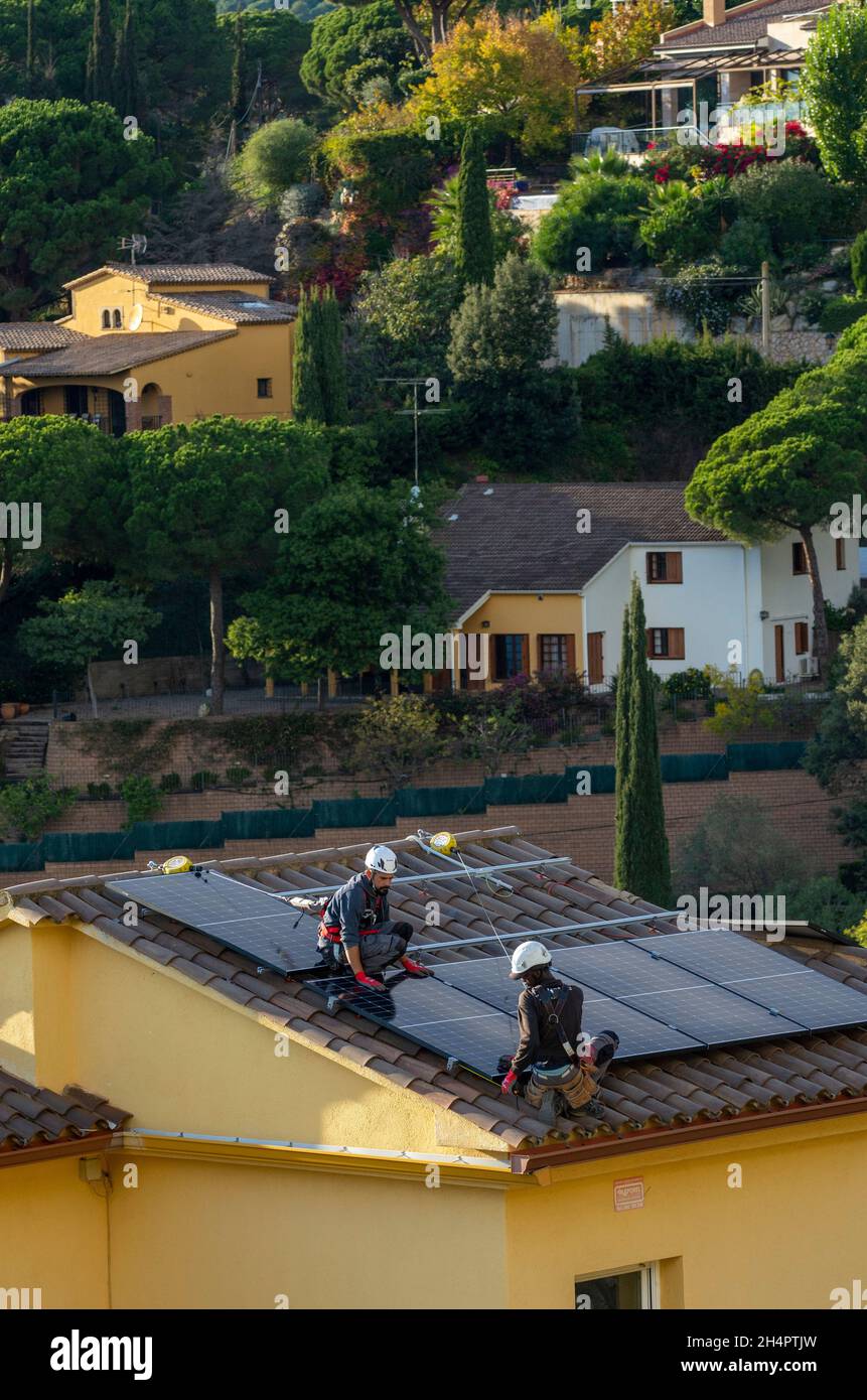 Elektrovertragsarbeiter von HolaLuz installieren Solarzellen auf dem Dach eines Wohnhauses während des Aufbaus eines subventionierten Stromversorgungssystems für Privathäuser nördlich von Barcelona in Carbils, Katalonien, Spanien. © Olli Geibel Stockfoto