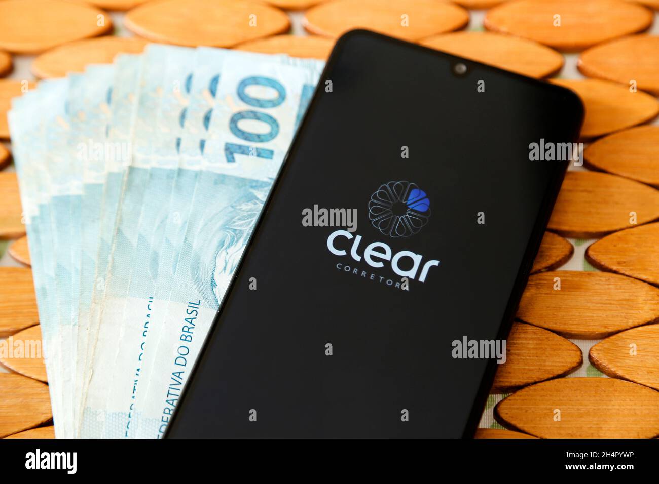 Minas Gerais, Brasilien - 19. April 2021: Smartphone-Handy-Bildschirm mit Clear Broker Marke und mehrere brasilianische echte Rechnungen Stockfoto