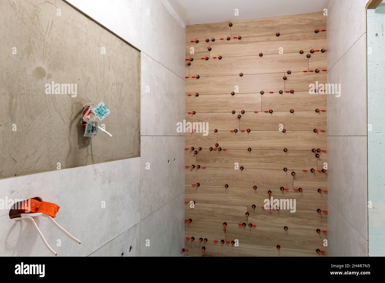 Fliesen an die Wand legen. Badezimmer während der Arbeiten. Stockfoto