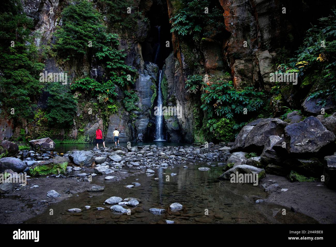 Mutter und Sohn betrachten den Wasserfall Cascata do Salto do Cabrito auf der Insel Sao Miguel, Azoren, Portugal Stockfoto