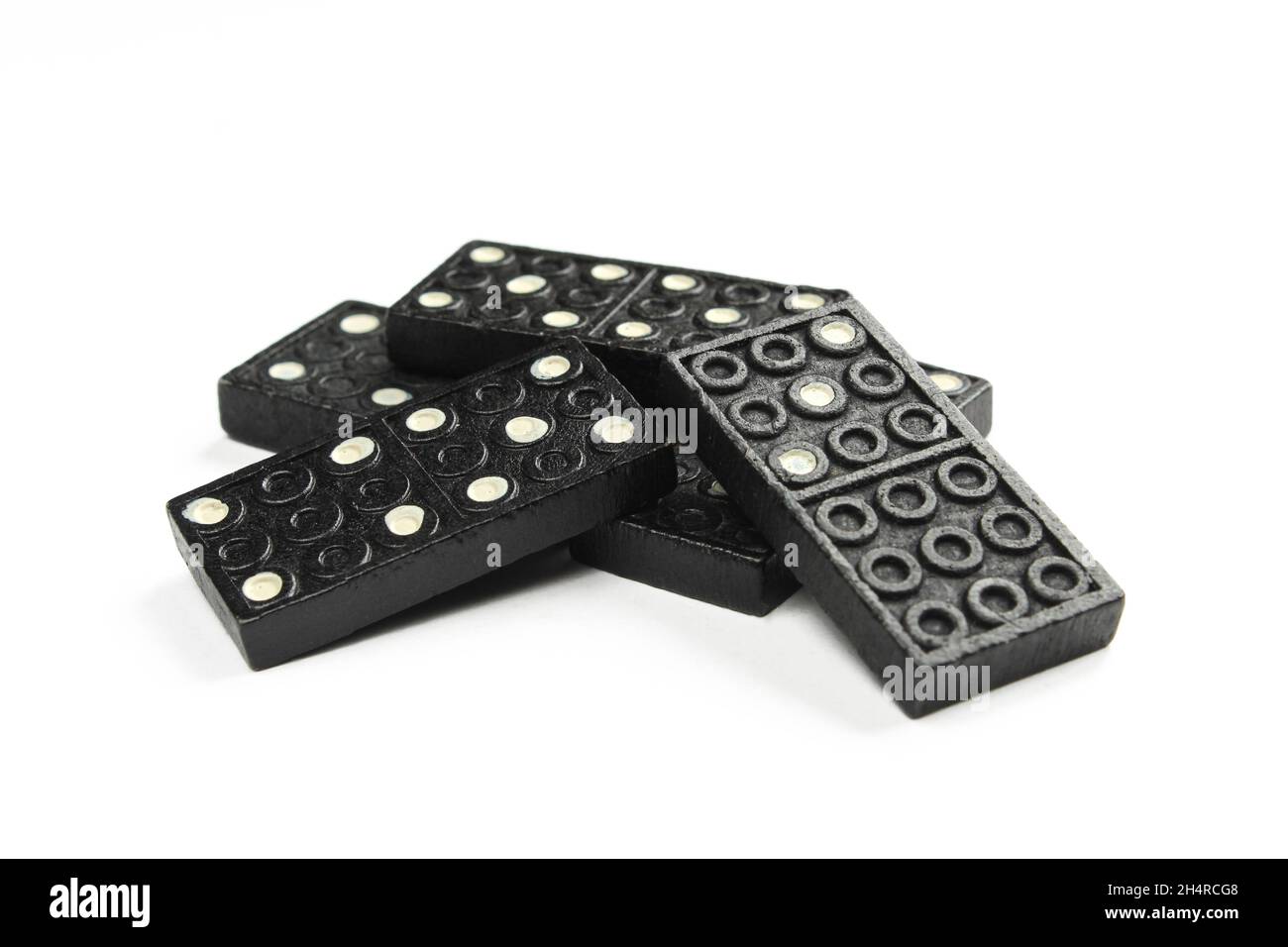 Haufen schwarzer Dominosteine auf weißem Hintergrund isoliert. Spiel für Familie und Freunde Stockfoto