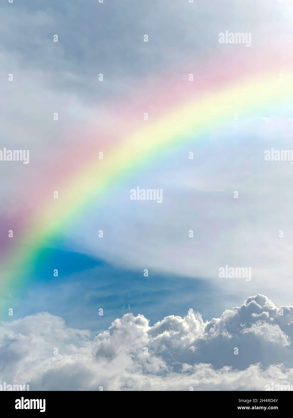 Ein himmlischer Regenbogen vor einer wunderschönen Wolkenlandschaft. Stockfoto