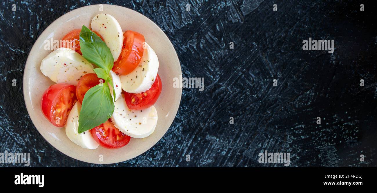 Banner mit Tomate und Mozzarella Kreisen mit Basilikumblättern. Servieren von italienischem Caprese-Salat. Flaches Lay. Weicher Fokus. Draufsicht Stockfoto