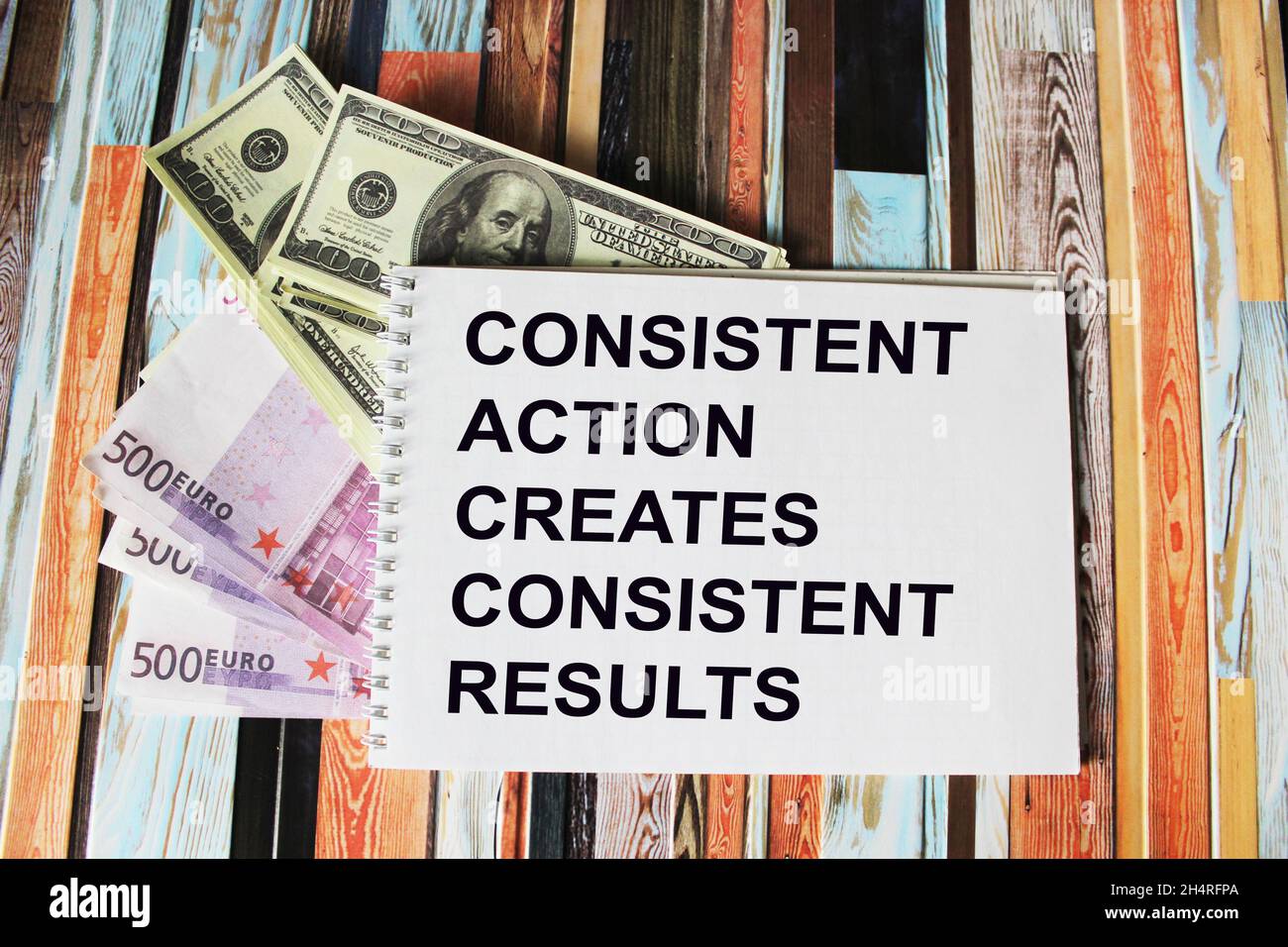 Sequenzielle Aktionen erzeugen ein konsistentes Ergebnis, Text auf Notizblock, neben Dollar und Euro auf einem Schreibtisch Stockfoto