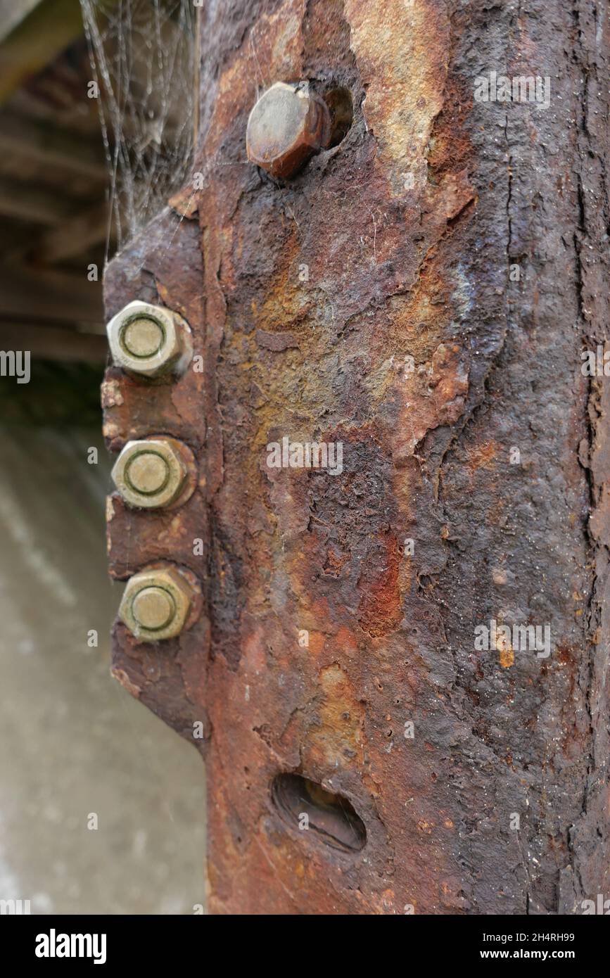 Nahaufnahme der rostigen alten Metallsäule mit Stahlmuttern und -Schrauben Stockfoto