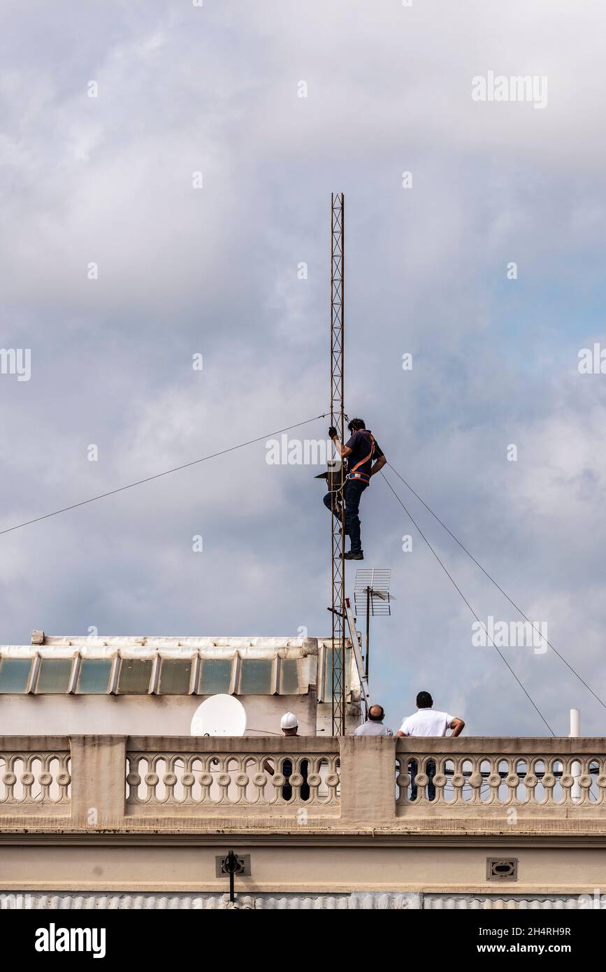 Barcelona, Spanien - 1. Oktober 2021: Bauarbeiter demontieren eine Antenne auf dem Dach eines Wohnhauses in Barcelona, Spanien Stockfoto