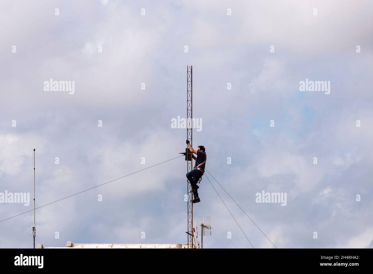 Barcelona, Spanien - 1. Oktober 2021: Bauarbeiter demontieren eine Antenne auf dem Dach eines Wohnhauses in Barcelona, Spanien Stockfoto