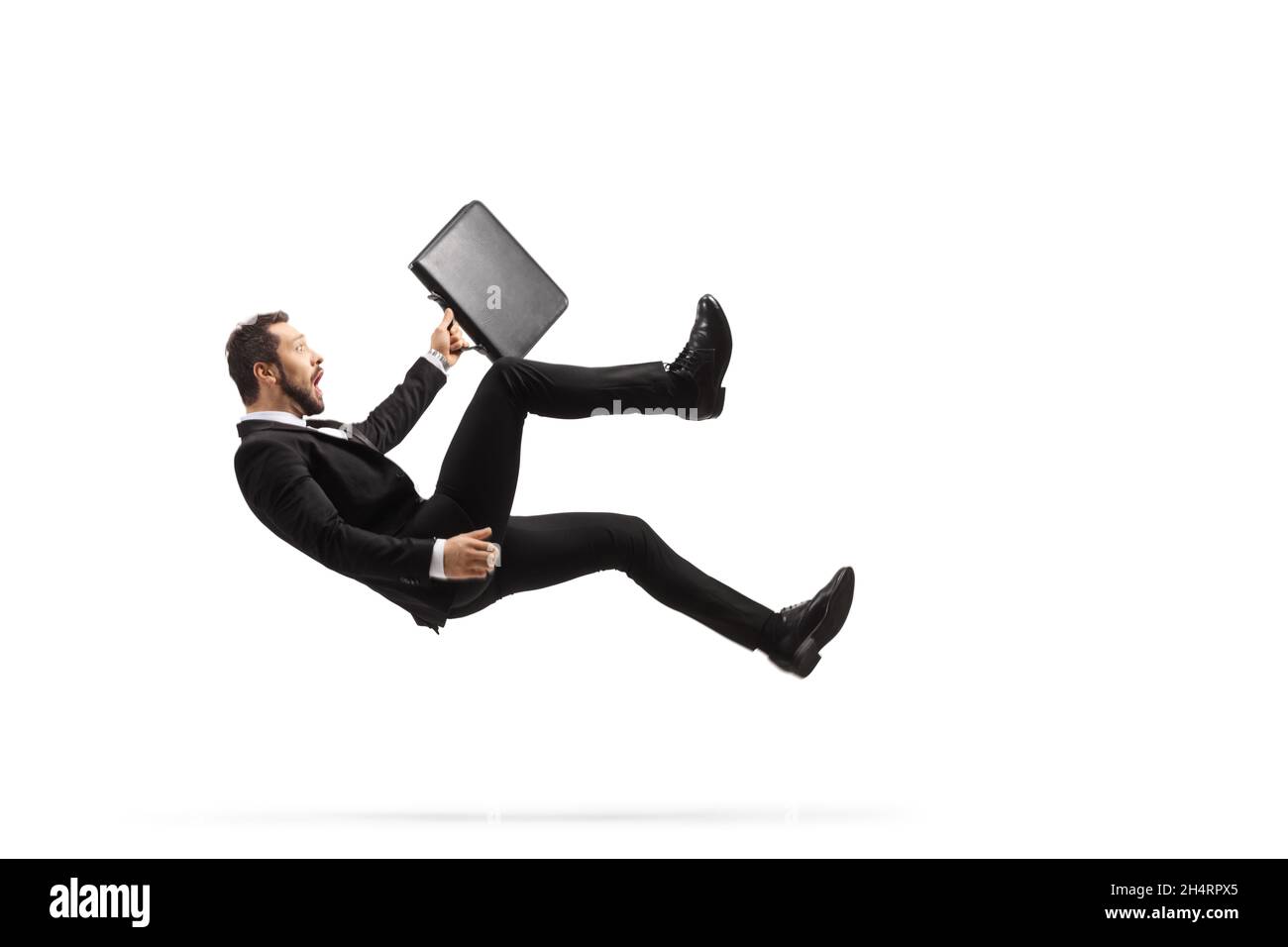 Geschäftsmann mit einer Aktentasche, die auf den Boden fällt, isoliert auf weißem Hintergrund Stockfoto