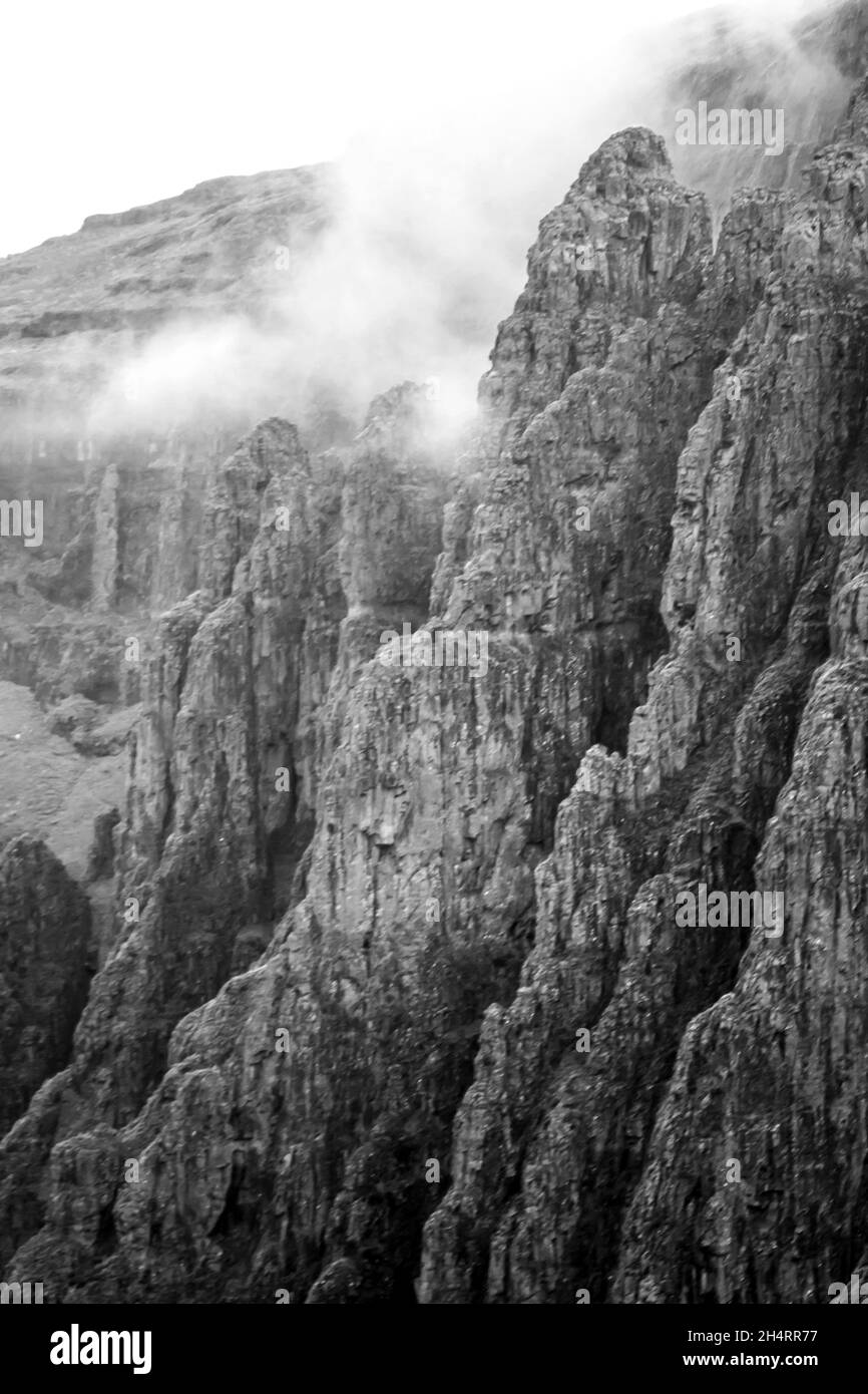 Nahsicht auf die steilen zerklüfteten Klippen der Drakensberg Mountains in Monochrome, entlang der Grenze zwischen Südafrika und Lesotho. Diese kultigen clif Stockfoto
