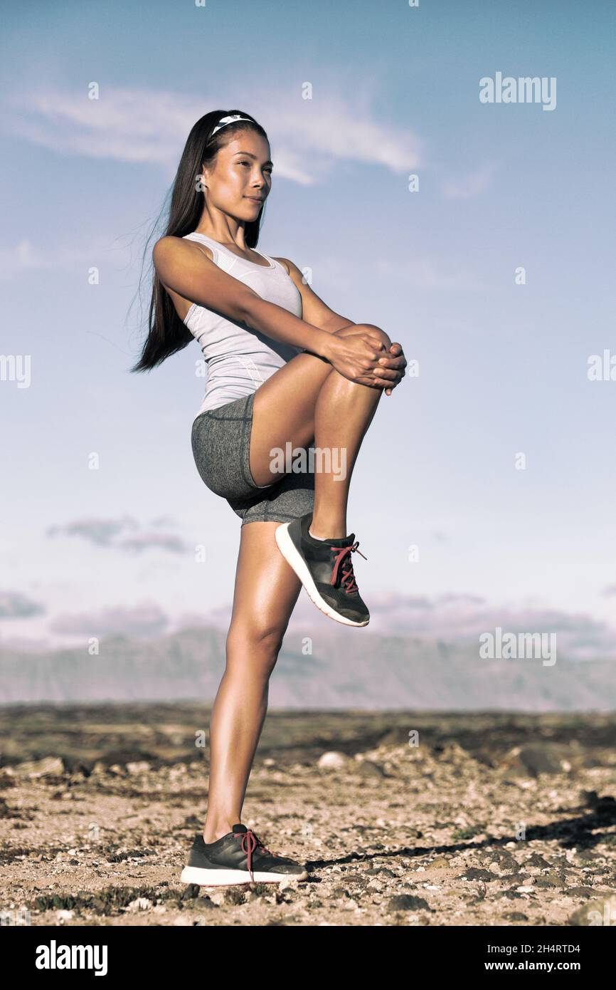 Beinstreckung Übung Fitness-Läuferin Frau beim Laufen Warm-up, Oberschenkelmuskeln dehnen stehen mit einem einzigen Knie bis zur Brust strecken. Weiblich Stockfoto